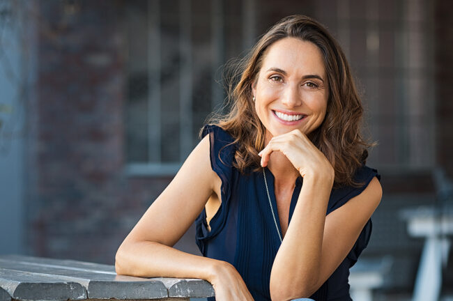 Portrait of beautiful mature woman sitting at coffee shop. Happy