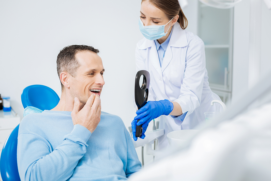 bigstock–211363351 A dentist talking with a patient in Calgary, AB.