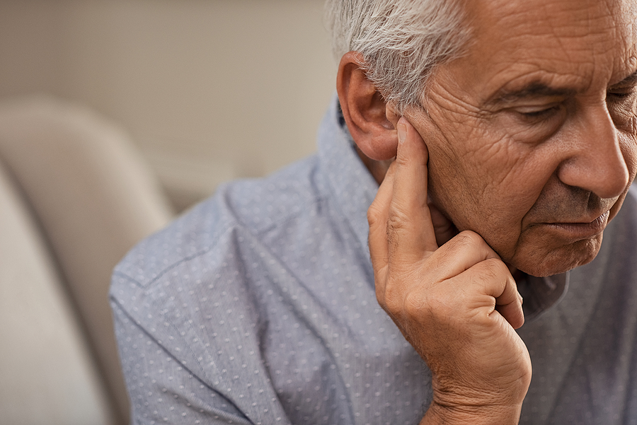 Side view of senior man with symptom of hearing loss. Mature man