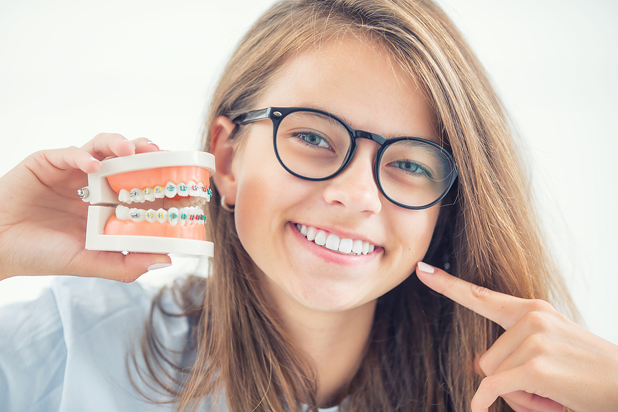 Model Of A Dental Braces In The Hand Of A Young Girl With Aligne